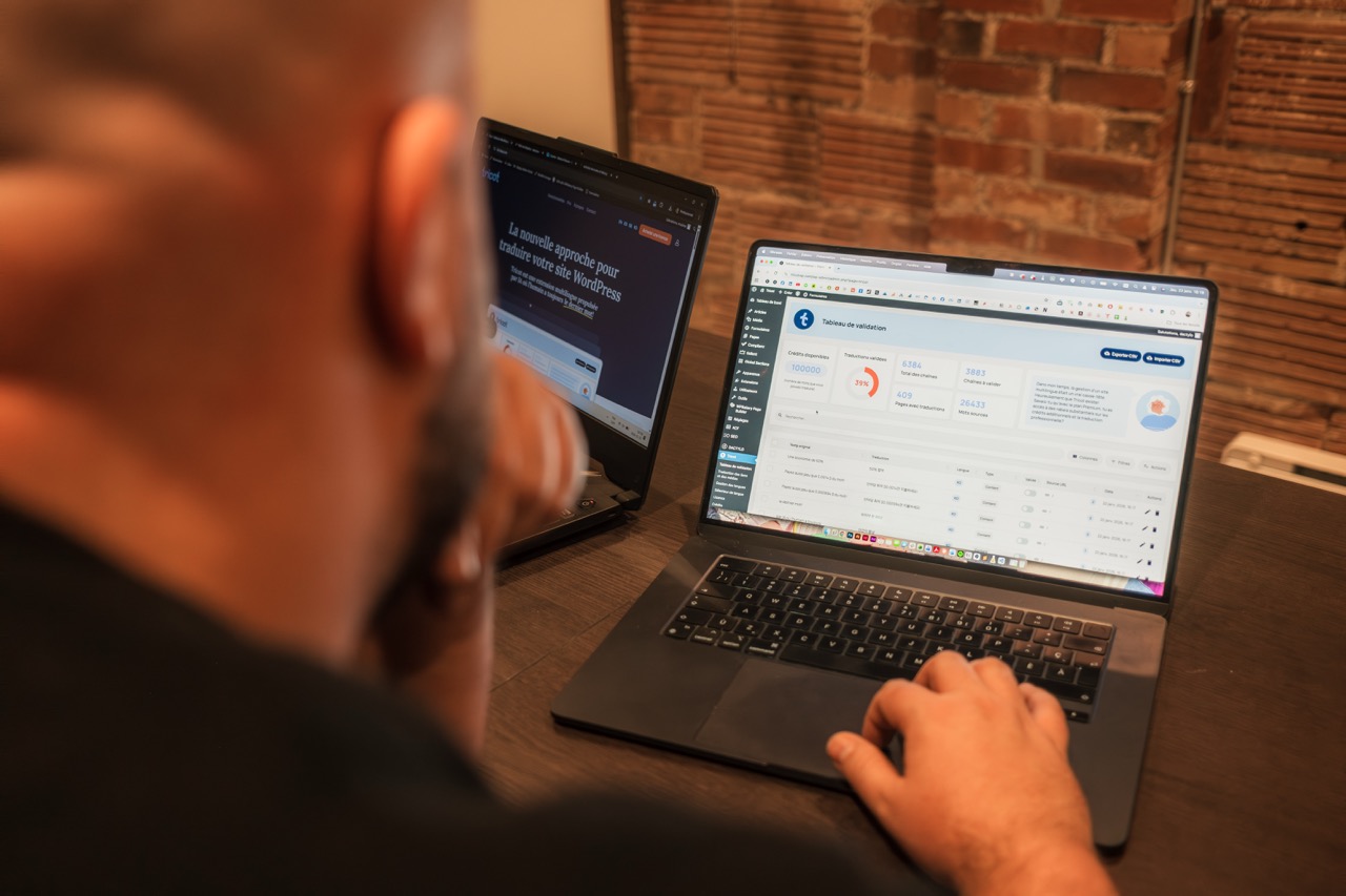 Homme travaillant sur deux ordinateurs portables au bureau