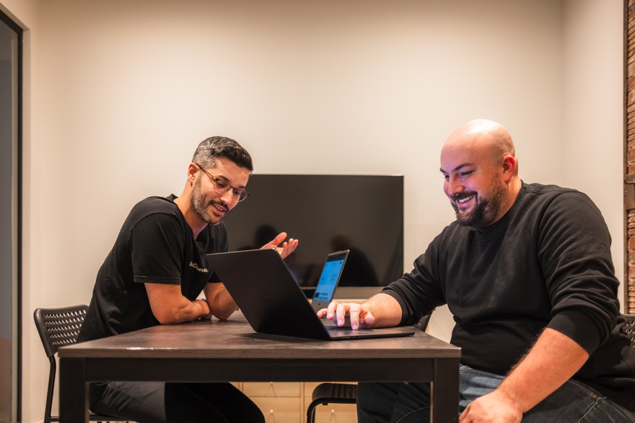 Collègues discutant autour d’un ordinateur portable